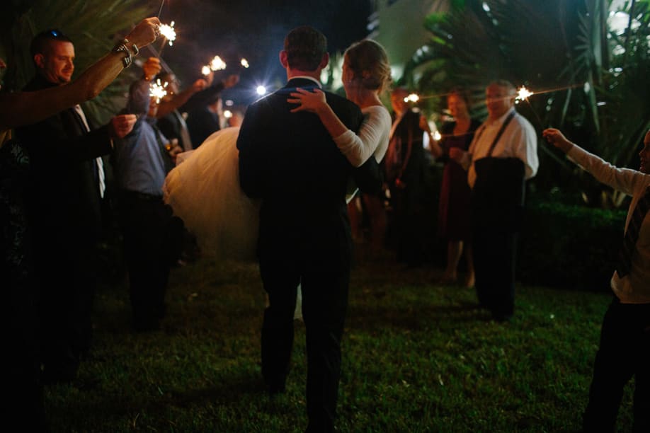 Groom is carrying his Bride through a sparkler grand exit at The Lake Mary Westin