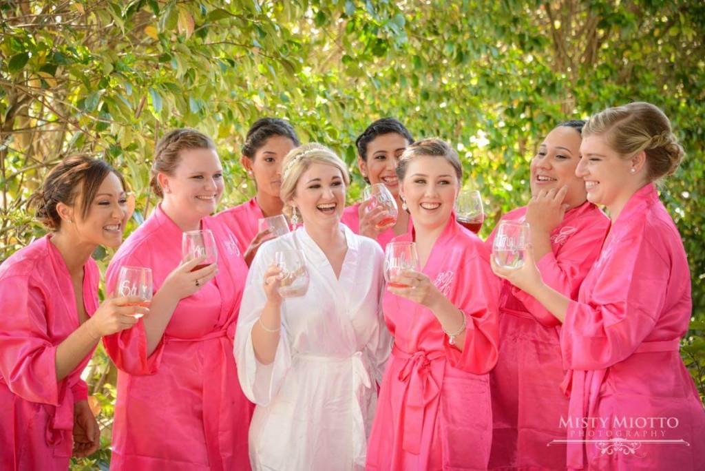 Bride with her bridesmaids. White and pink shiny bathrobes. 