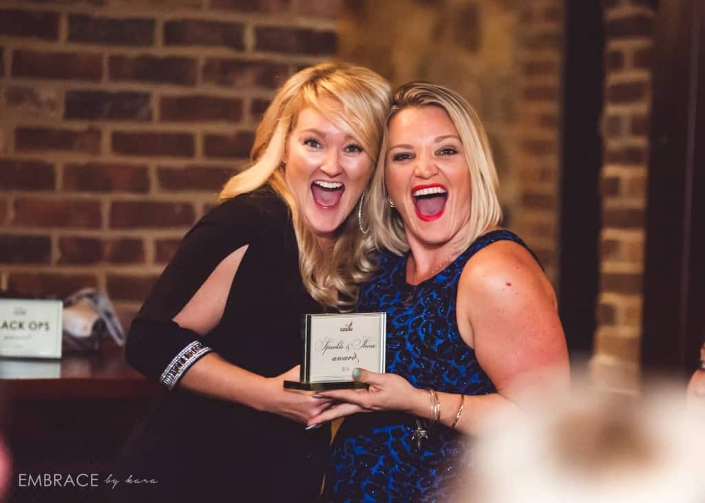 Kristin Wilson and Gaby Durand of Our DJ Rocks holding up award at holiday party