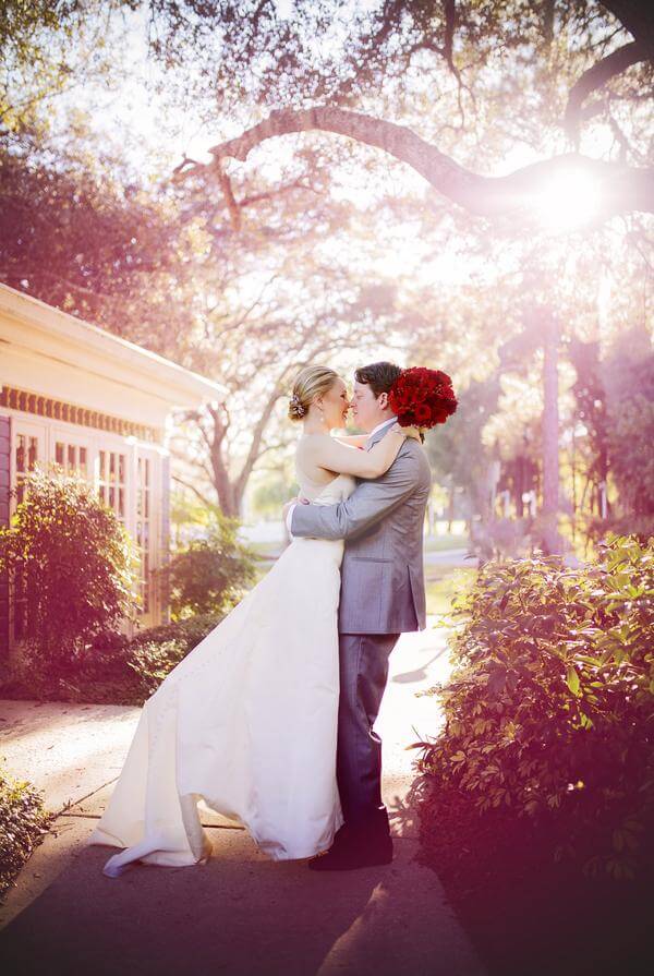 bride and groom wedding photo at Highland Manor. grey wedding tuxedo. White wedding dress. Red wedding bouquet.
