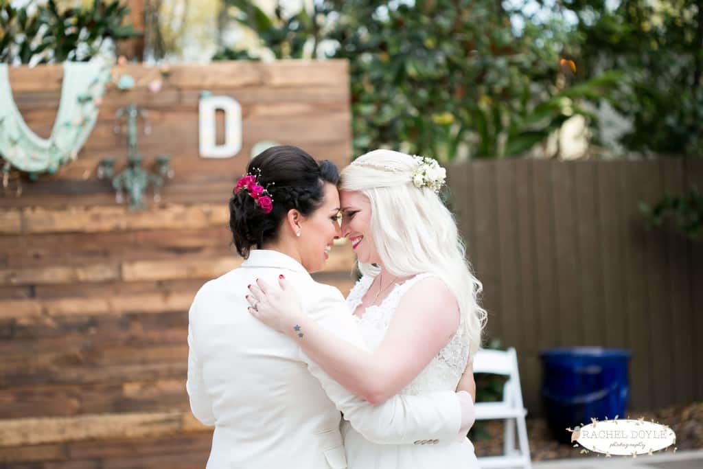 Same sex orlando wedding dancing to first dance at The Veranda with wooden backdrop