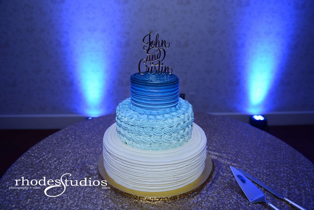 Lake mary events center wedding cake with cake topper and royal blue uplighting