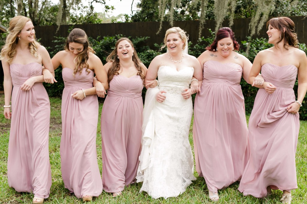 Delamater House wedding bride and bridesmaid photo while linking arms and smiling 