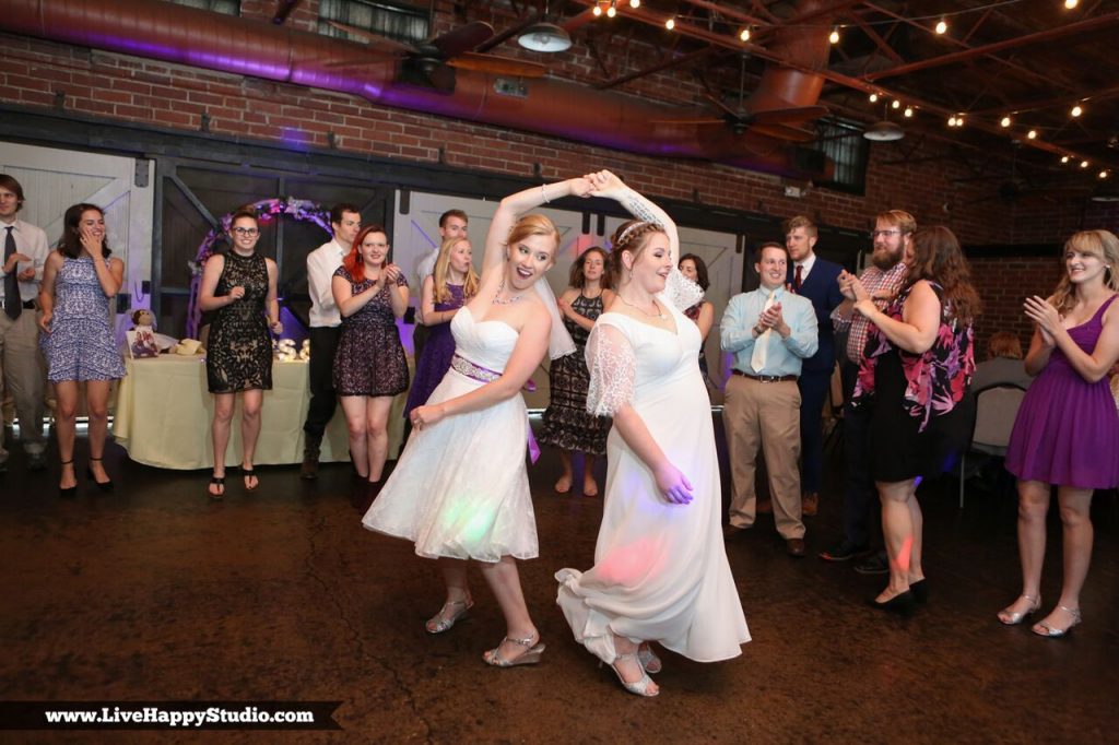 Brides spinning each other on dance floor