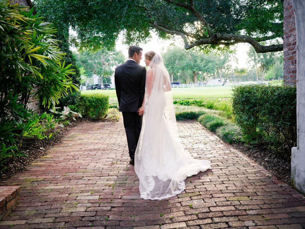 bride and groom walking away on brick path