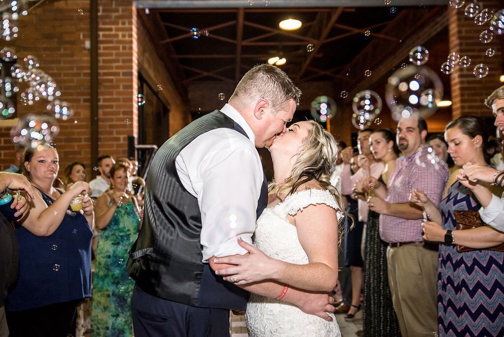 bride and groom kissing among cascade of bubbles