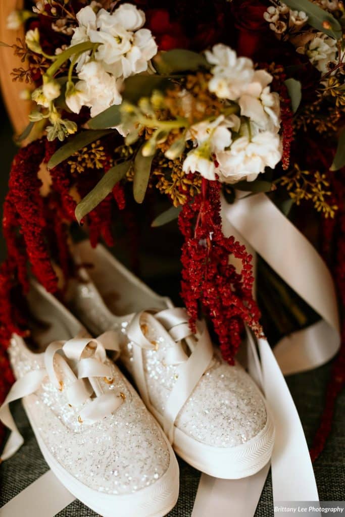 sparkly bridal sneakers next to bouquet