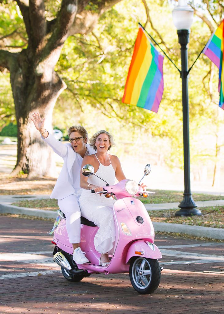 same sex wedding with feminine vibes arriving to the ceremony in a vespa