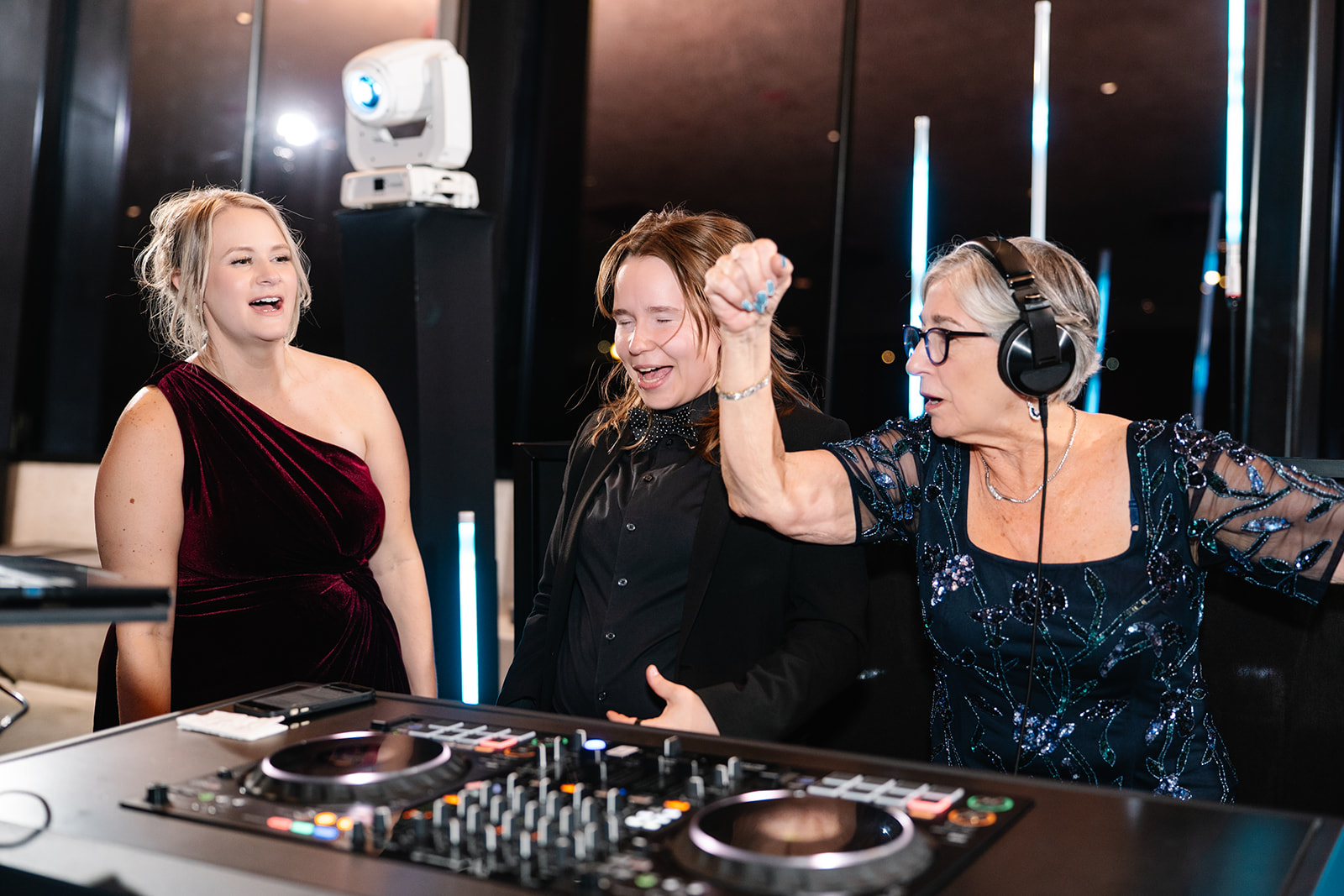 Two wedding guests behind the DJ booth