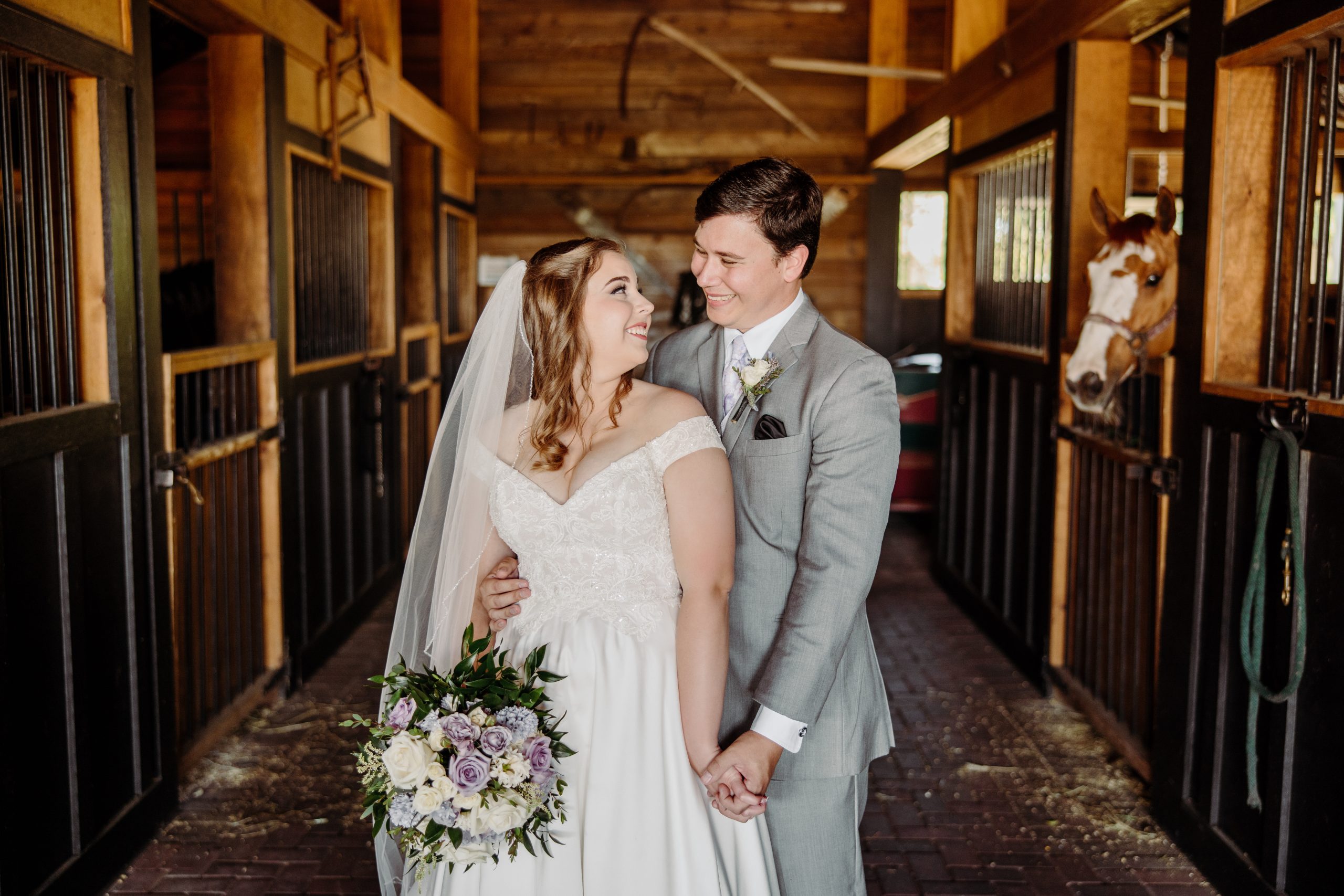 Amy and Tyler pose in horse stables at The Black Barn