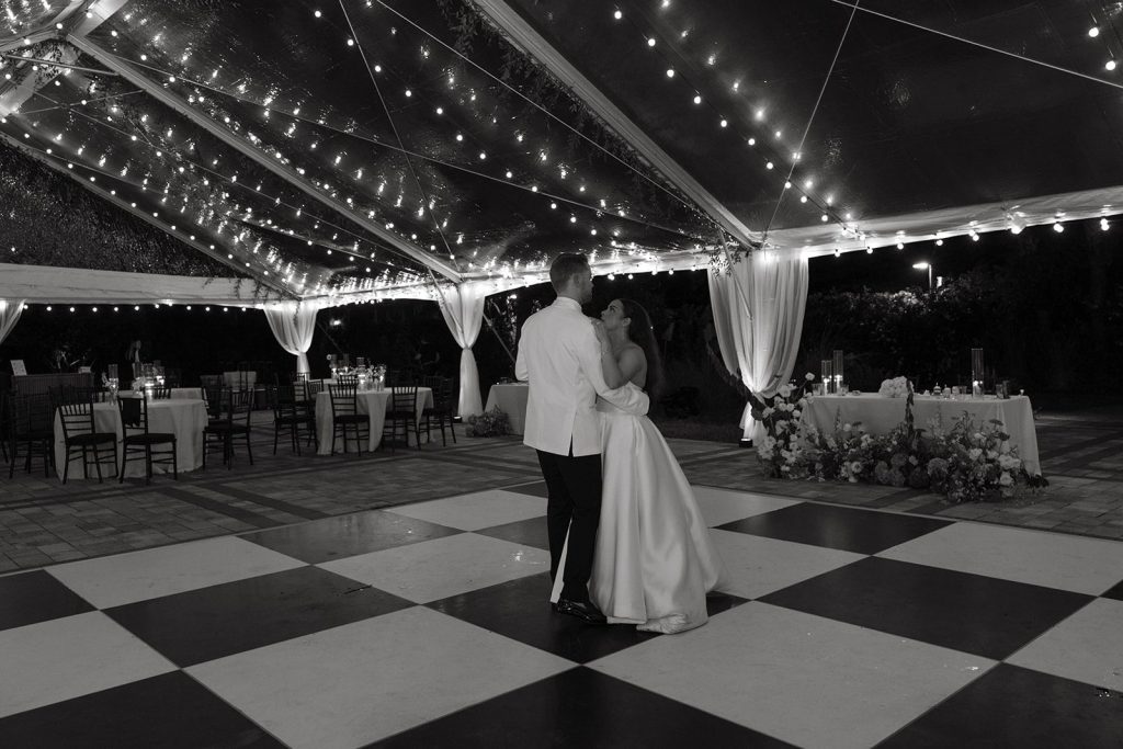 Couple dancing on the black and white checkerboard dance floor under the tent at Victoria 1883