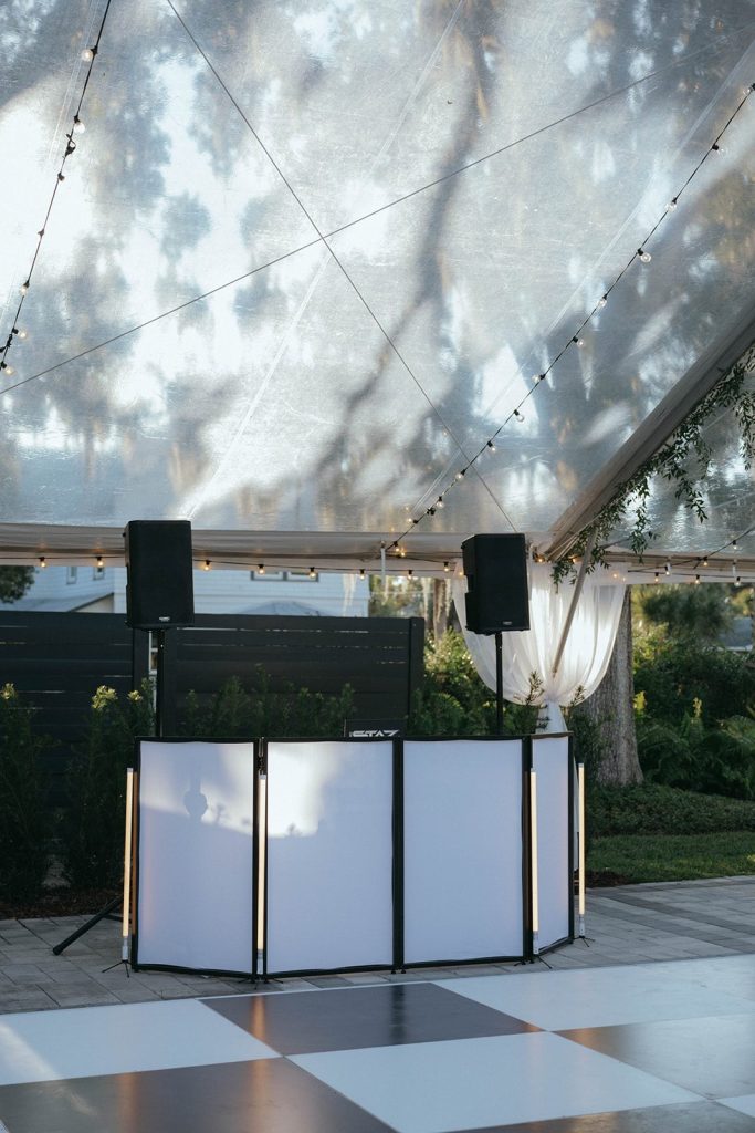 Our DJ Rocks DJ booth with LED facade and speakers on the checkerboard dance floor at Victoria 1883