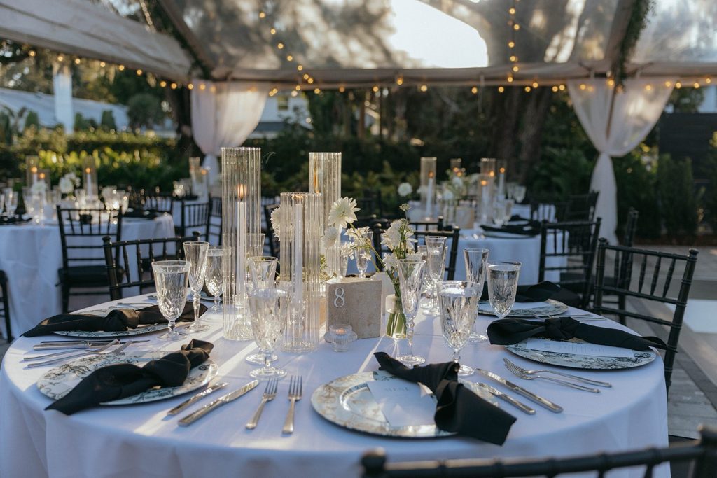 Reception table with crystal candle holders and black napkins under the tent at Victoria 1883